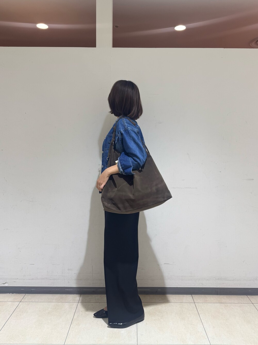 ブラック系のその他パンツ、ブルー系のデニムジャケット、ホワイト系のTシャツ/カットソーを着用したレディースの秋コーディネートの2枚目の写真