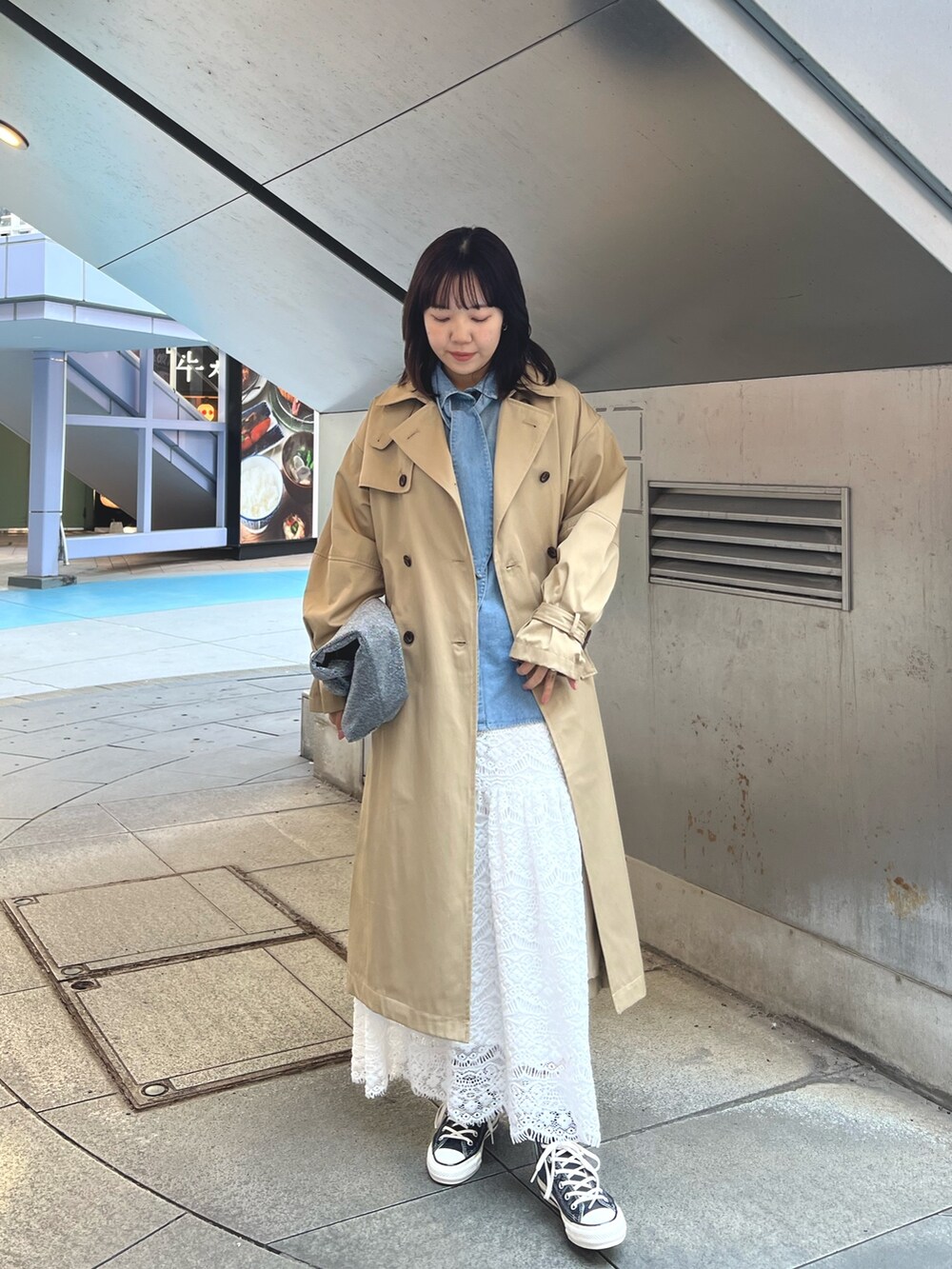 ホワイト系のスカート、ブルー系のシャツ/ブラウス、ベージュ系のトレンチコートを着用したレディースの冬コーディネートの3枚目の写真