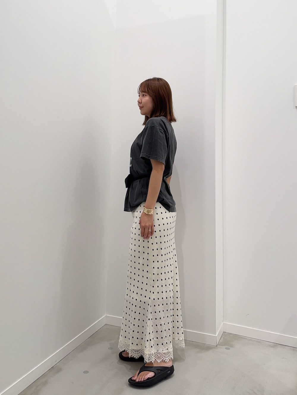 ホワイト系のスカート、ブラック系のTシャツ/カットソー、ブラック系のベルトを着用したレディースの夏コーディネートの2枚目の写真