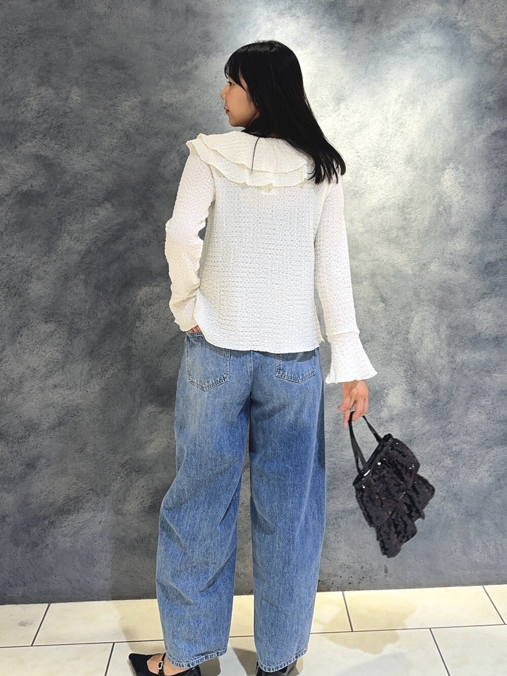 ホワイト系のTシャツ/カットソー、ブルー系のデニムパンツ、ブラック系のハンドバッグを着用したレディースの秋コーディネートの7枚目の写真