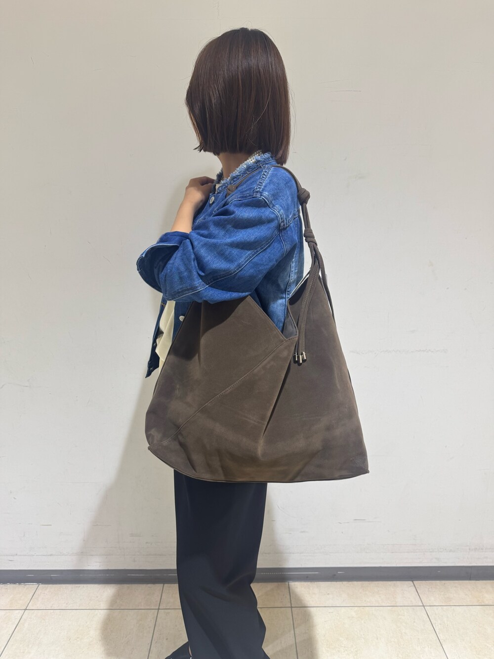 ブラック系のその他パンツ、ブルー系のデニムジャケット、ホワイト系のTシャツ/カットソーを着用したレディースの秋コーディネートの3枚目の写真
