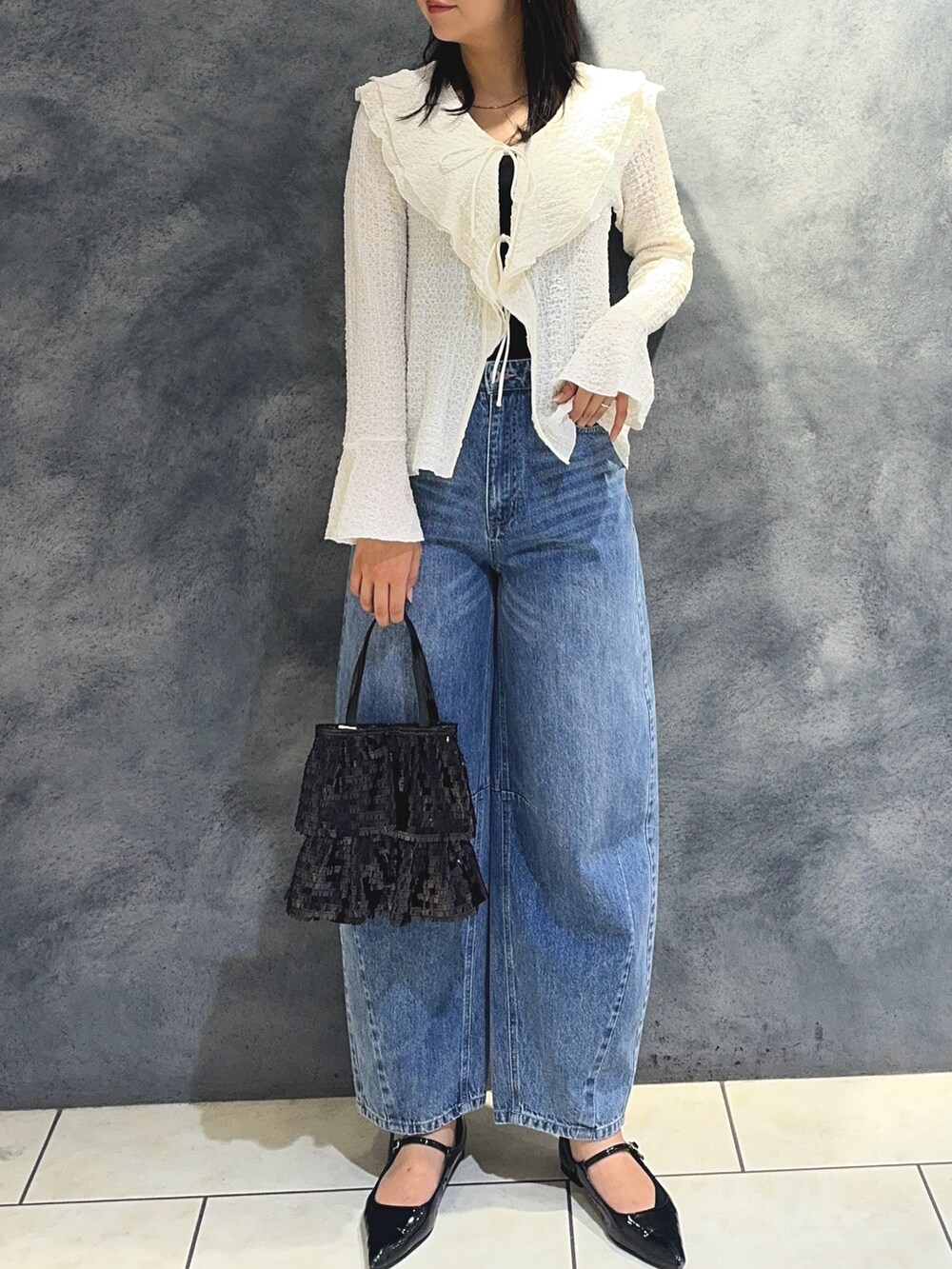 ホワイト系のTシャツ/カットソー、ブルー系のデニムパンツ、ブラック系のハンドバッグを着用したレディースの秋コーディネートの6枚目の写真