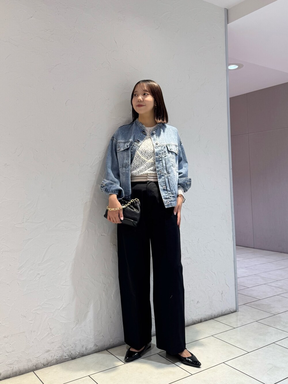 ブルー系のデニムジャケット、ブラック系のチノパンツ、ホワイト系のTシャツ/カットソーを着用したレディースの冬コーディネートの2枚目の写真