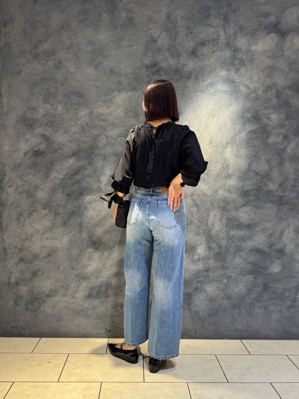 ブラック系のシャツ/ブラウス、ブルー系のデニムパンツを着用したレディースの春コーディネートの3枚目の写真