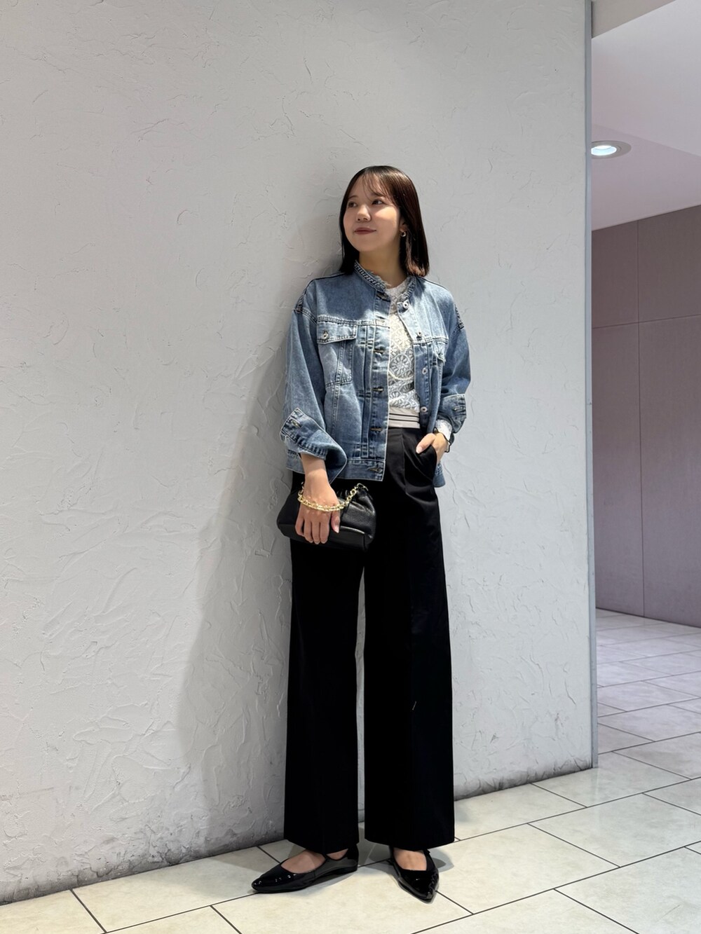 ブルー系のデニムジャケット、ブラック系のチノパンツ、ホワイト系のTシャツ/カットソーを着用したレディースの冬コーディネートの4枚目の写真