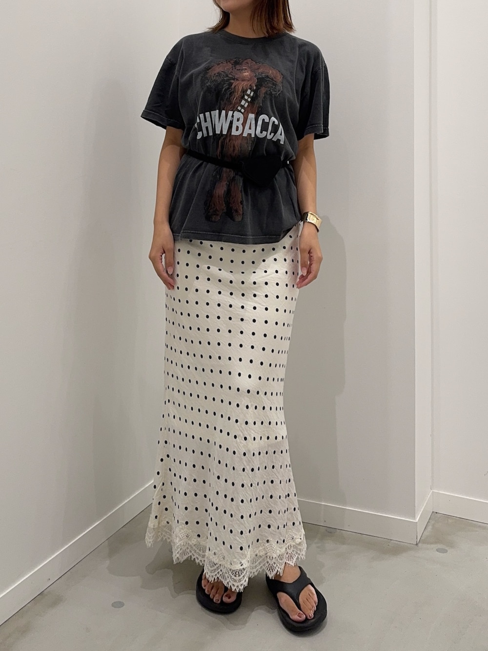 ホワイト系のスカート、ブラック系のTシャツ/カットソー、ブラック系のベルトを着用したレディースの夏コーディネートの3枚目の写真