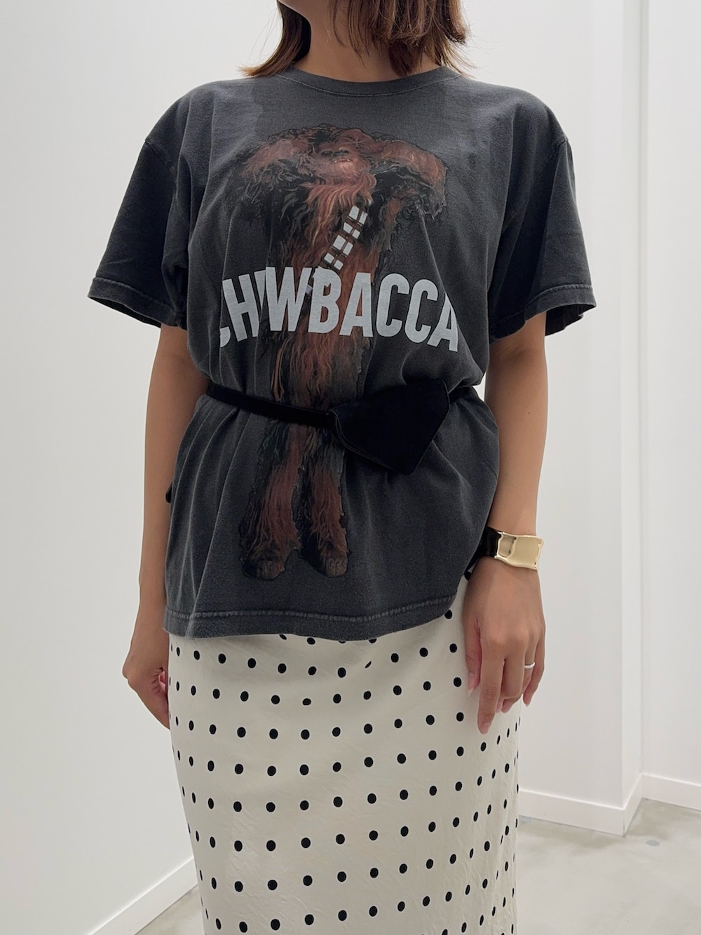 ホワイト系のスカート、ブラック系のTシャツ/カットソー、ブラック系のベルトを着用したレディースの夏コーディネートの4枚目の写真