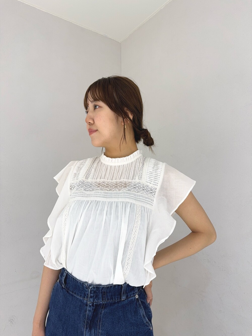 ホワイト系のシャツ/ブラウス、ブルー系のデニムパンツ、ゴールド系のかごバッグを着用したレディースの春コーディネートの6枚目の写真