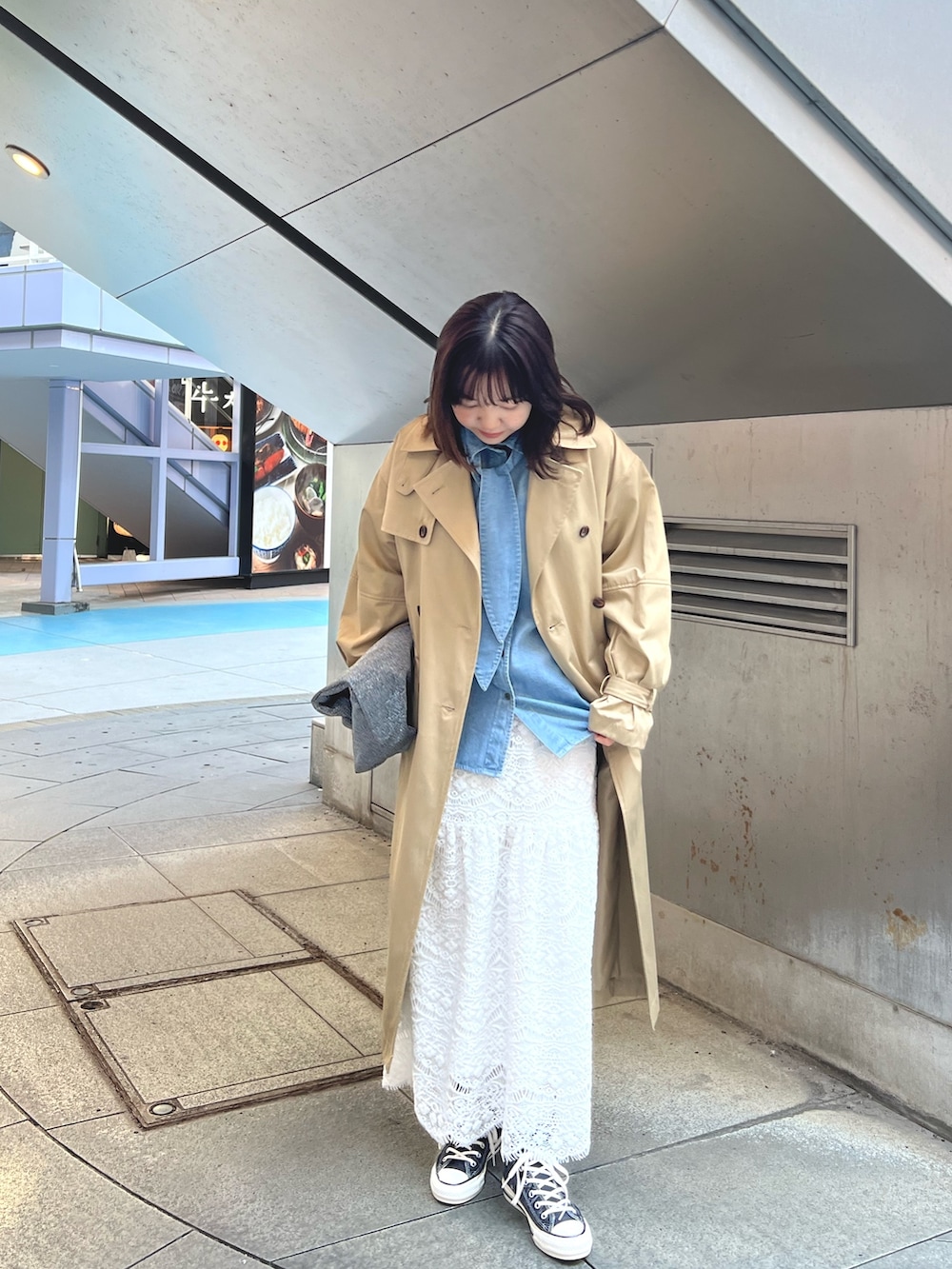 ホワイト系のスカート、ブルー系のシャツ/ブラウス、ベージュ系のトレンチコートを着用したレディースの冬コーディネートの2枚目の写真