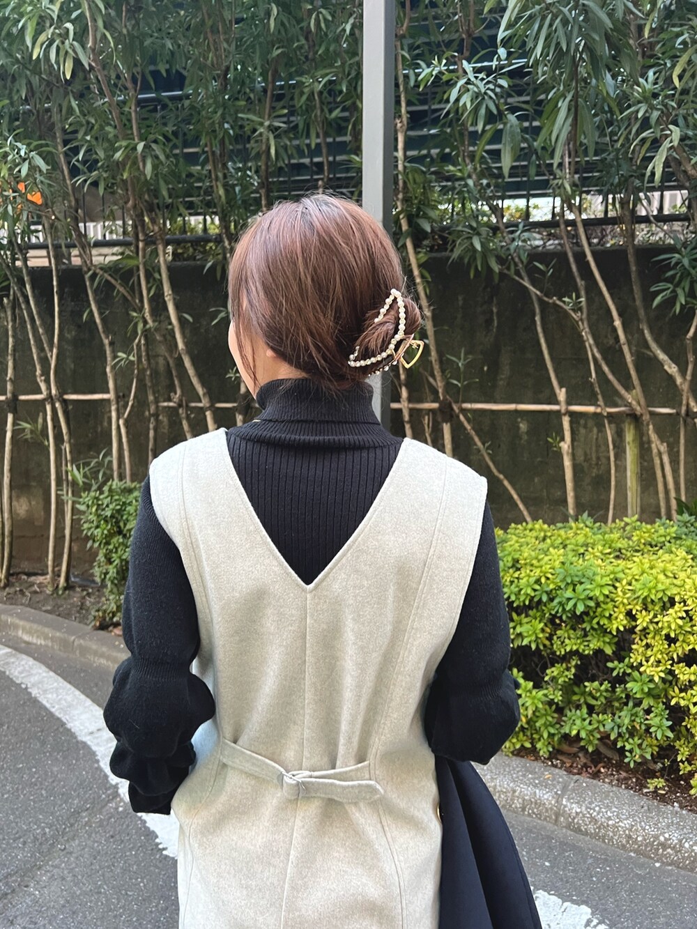 グレー系のワンピース、ブラック系のニット/セーター、ゴールド系のネックレスを着用したレディースの冬コーディネートの4枚目の写真