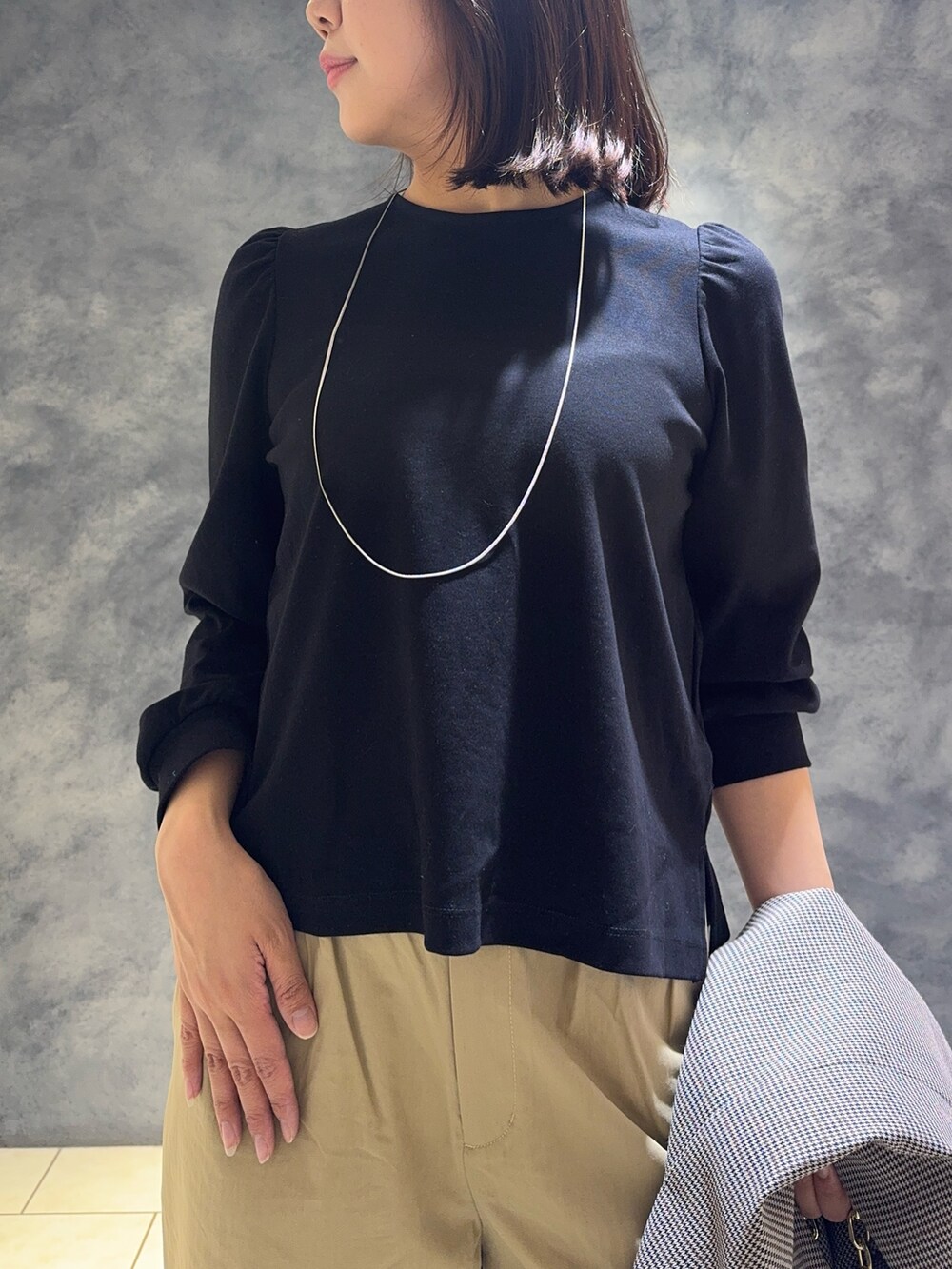 ブラック系のTシャツ/カットソー、ベージュ系のその他パンツ、ブラック系のその他シューズを着用したレディースの春コーディネートの4枚目の写真