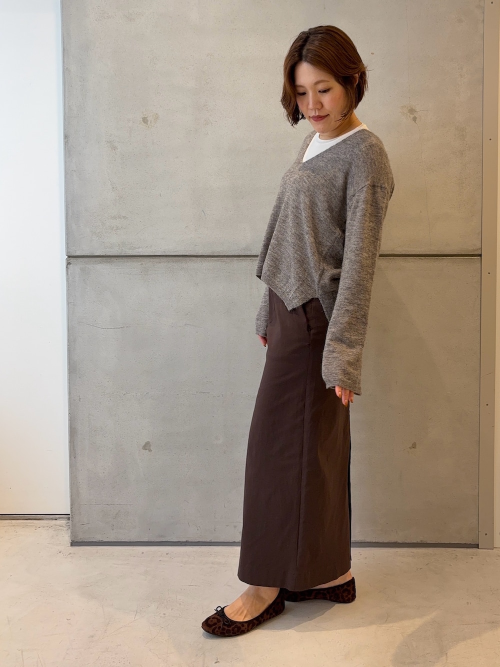 ホワイト系のTシャツ/カットソー、グレー系のニット/セーター、ブラウン系のスカートを着用したレディースの秋コーディネートの3枚目の写真