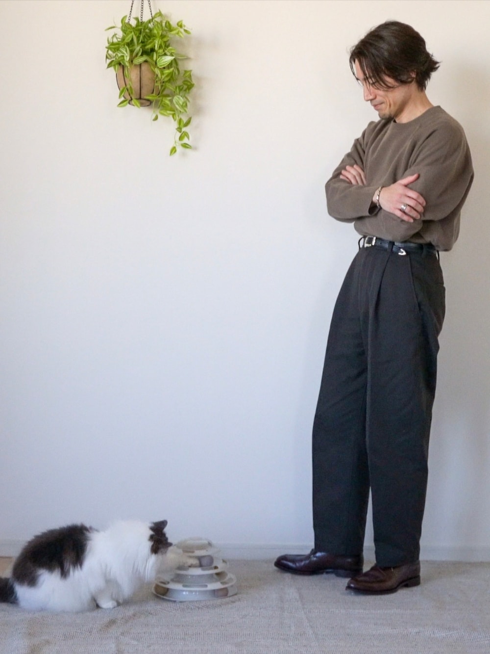 ブラウン系のチノパンツ、ブラウン系のドレスシューズ、ブラウン系のニット/セーターを着用したメンズの冬コーディネートの4枚目の写真