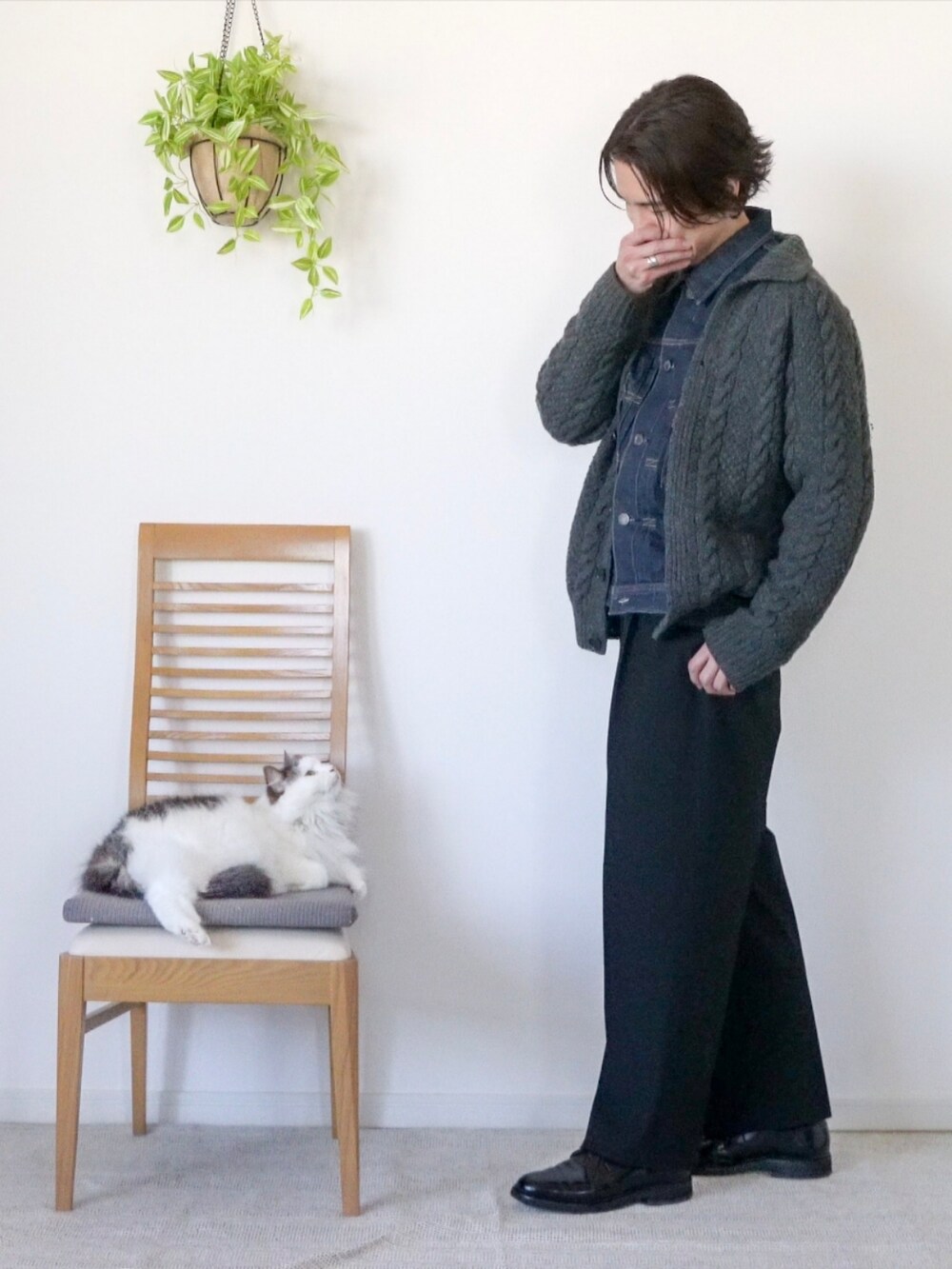 ブルー系のデニムジャケット、グレー系のカーディガン/ボレロ、ブラック系のスラックスを着用したメンズの冬コーディネートの2枚目の写真