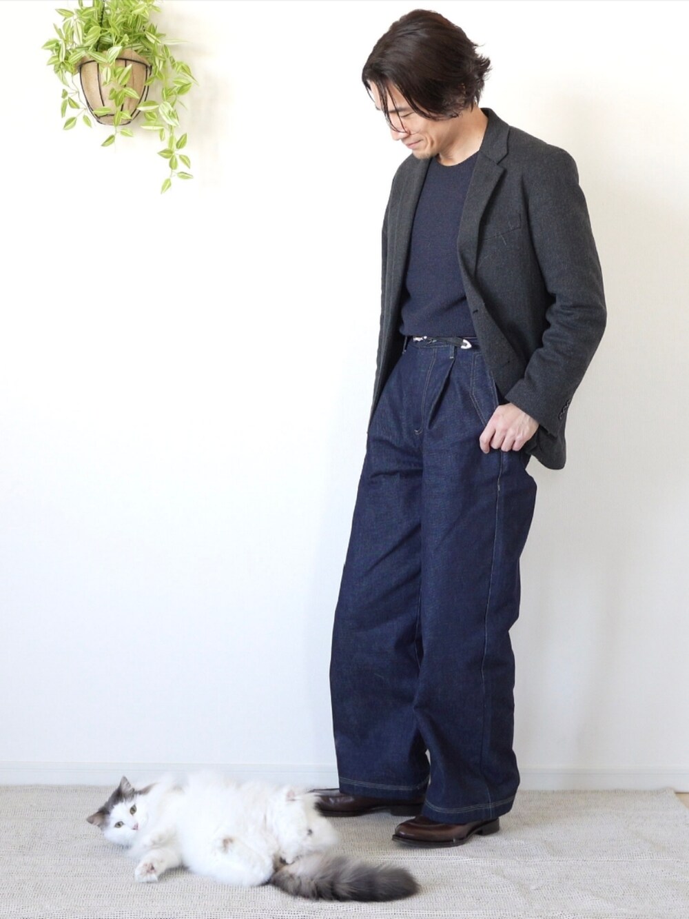 ブルー系のデニムパンツ、ブラウン系のドレスシューズ、グレー系のテーラードジャケットを着用したメンズの冬コーディネートの2枚目の写真