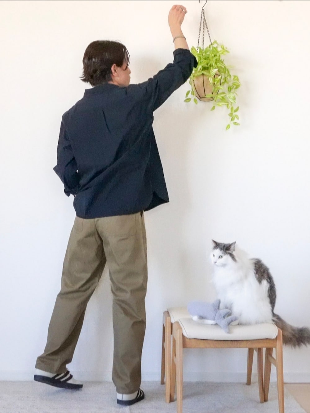 ホワイト系のスニーカー、ブラウン系のチノパンツ、ブラック系のシャツ/ブラウスを着用したメンズの冬コーディネートの2枚目の写真