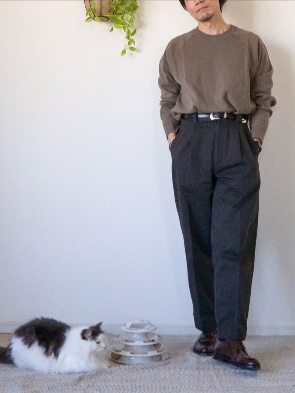 ブラウン系のチノパンツ、ブラウン系のドレスシューズ、ブラウン系のニット/セーターを着用したメンズの冬コーディネートの3枚目の写真