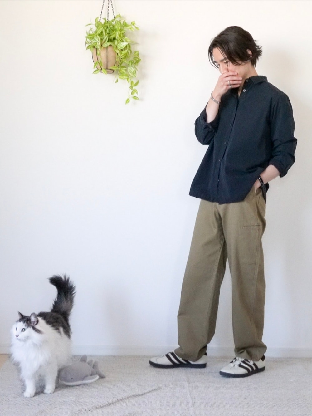 ホワイト系のスニーカー、ブラウン系のチノパンツ、ブラック系のシャツ/ブラウスを着用したメンズの冬コーディネートの3枚目の写真