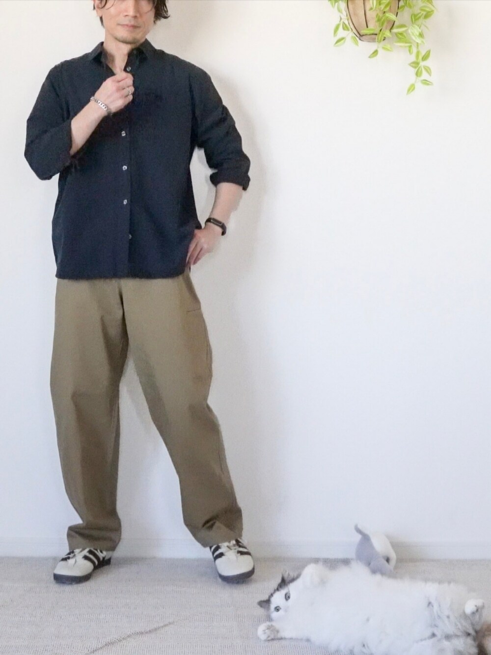 ホワイト系のスニーカー、ブラウン系のチノパンツ、ブラック系のシャツ/ブラウスを着用したメンズの冬コーディネートの4枚目の写真