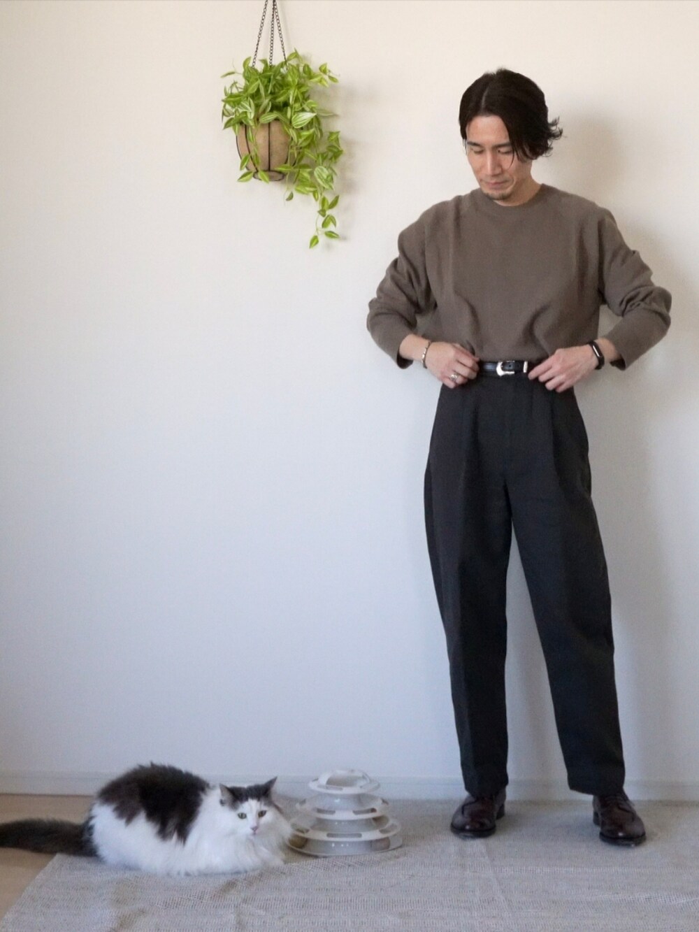 ブラウン系のチノパンツ、ブラウン系のドレスシューズ、ブラウン系のニット/セーターを着用したメンズの冬コーディネートの2枚目の写真