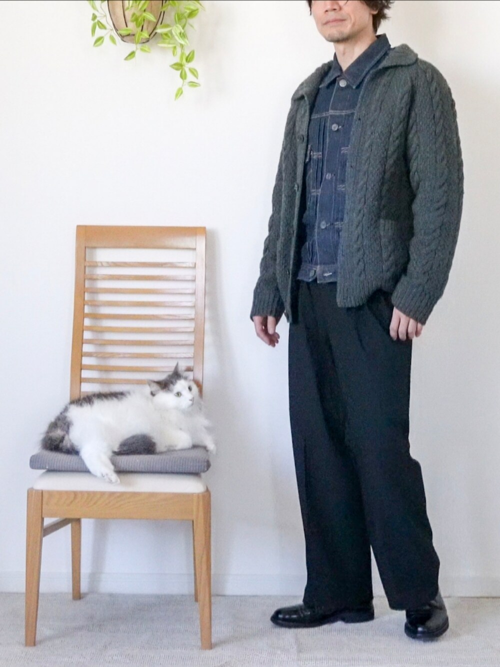 ブルー系のデニムジャケット、グレー系のカーディガン/ボレロ、ブラック系のスラックスを着用したメンズの冬コーディネートの3枚目の写真