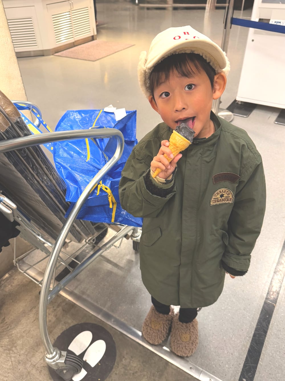 グリーン系のジャケット/アウター、ホワイト系のキャップを着用したキッズの冬コーディネートの2枚目の写真