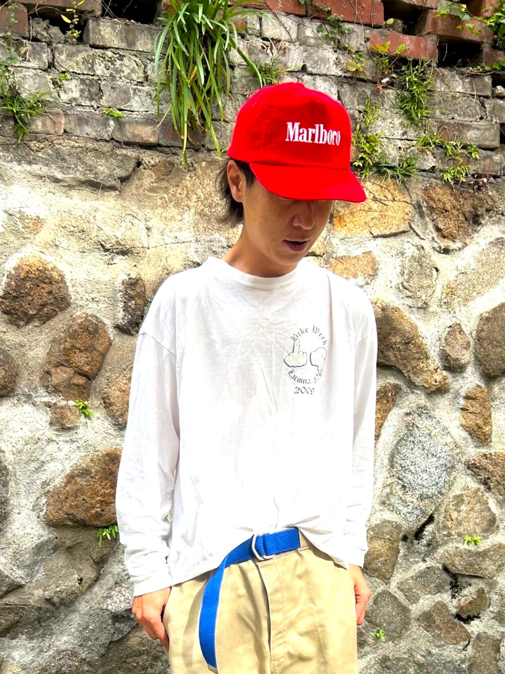 ホワイト系のTシャツ/カットソー、ベージュ系のチノパンツ、ブラック系のスニーカーを着用したメンズの秋コーディネートの2枚目の写真