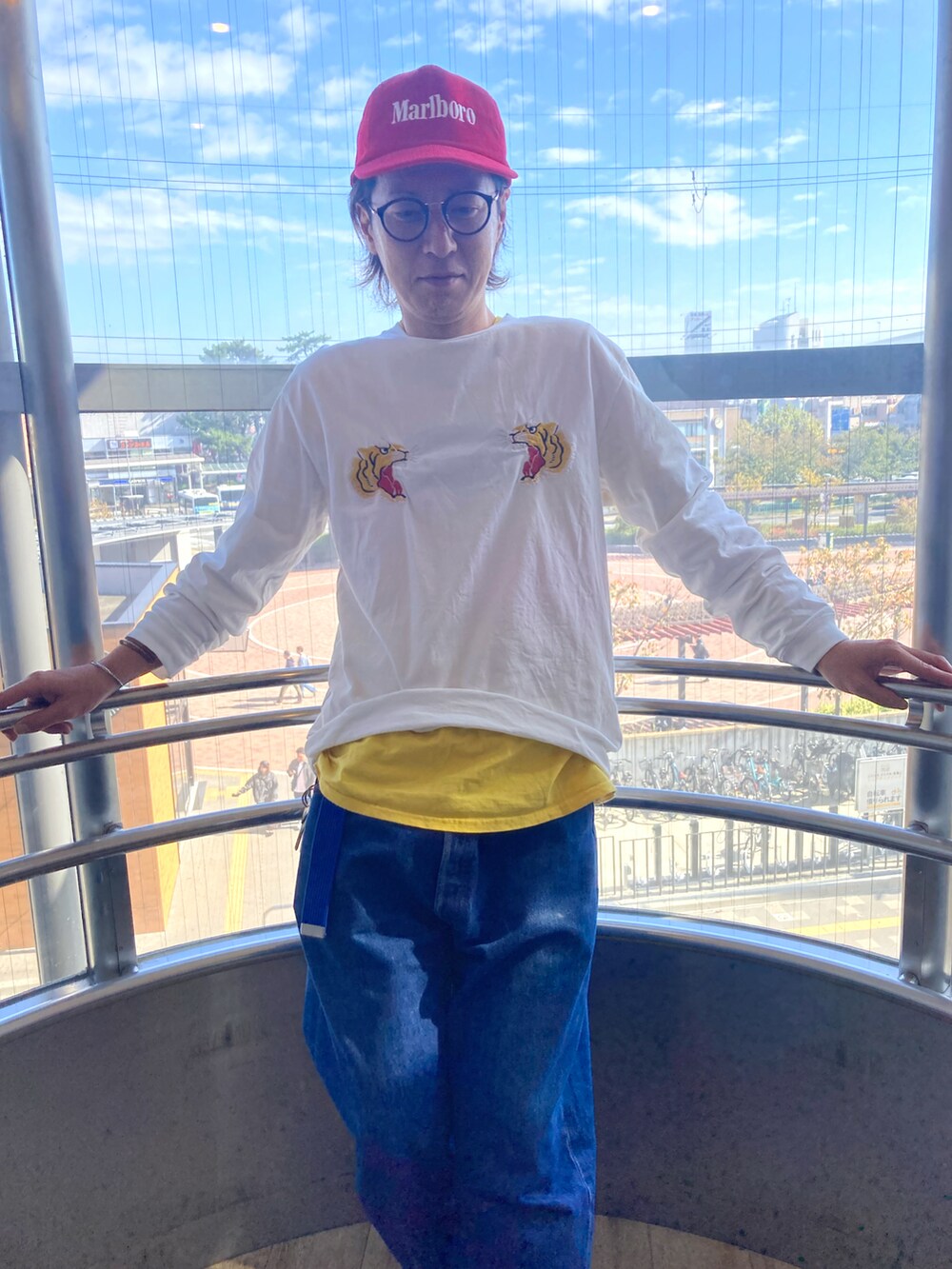 ホワイト系のTシャツ/カットソー、ブルー系のデニムパンツ、ブラック系のスニーカーを着用したメンズの秋コーディネートの2枚目の写真