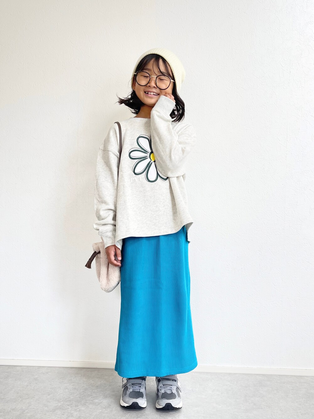 ホワイト系のスウェット、ブルー系のスカート、グレー系のスニーカーを着用したキッズの秋コーディネートの2枚目の写真