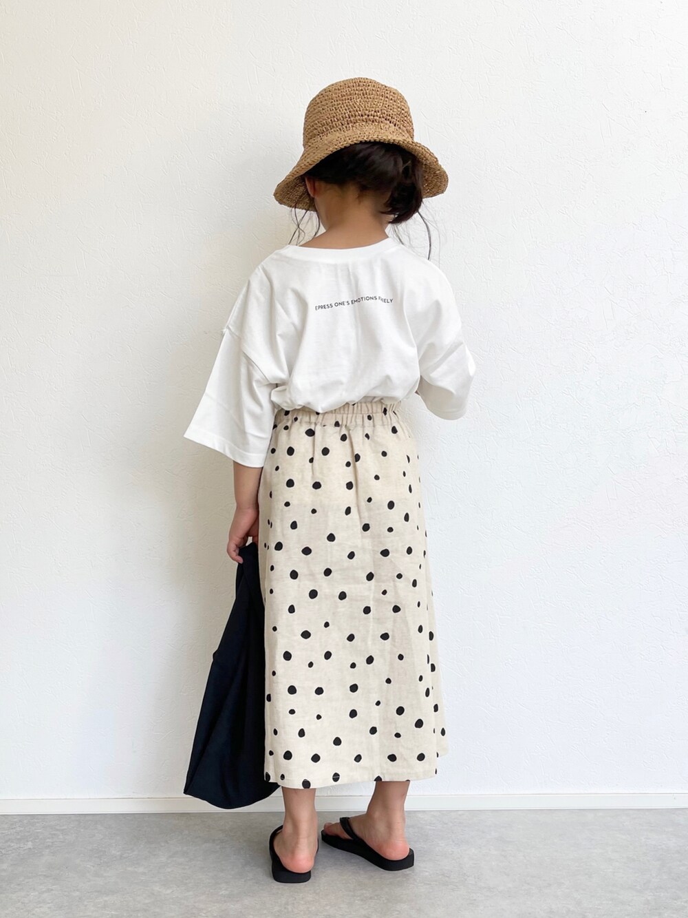 ホワイト系のスカート、ホワイト系のTシャツ/カットソー、ブラック系のエコバッグ/サブバッグを着用したキッズの春コーディネートの5枚目の写真