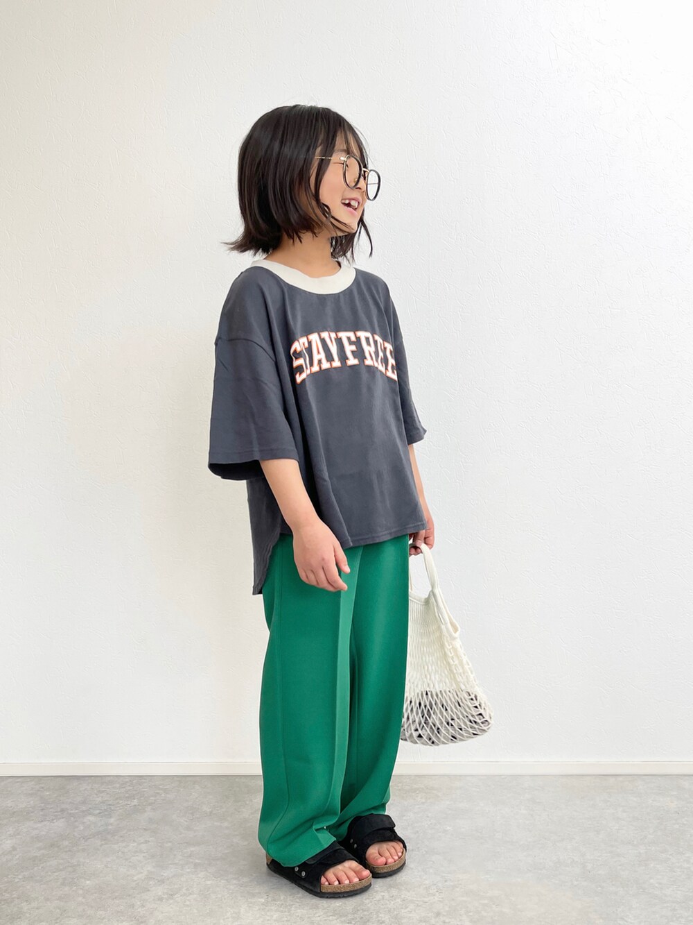 グリーン系のスラックス、グレー系のTシャツ/カットソー、ブルー系のデニムジャケットを着用したキッズの春コーディネートの4枚目の写真