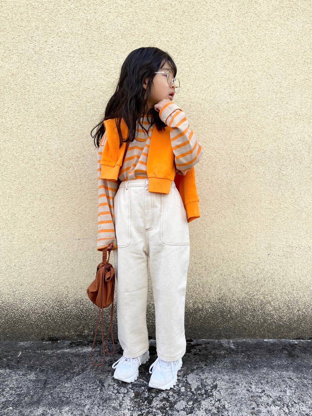 オレンジ系のTシャツ/カットソー、オレンジ系のスウェット、ホワイト系のその他パンツを着用したキッズの冬コーディネートの2枚目の写真