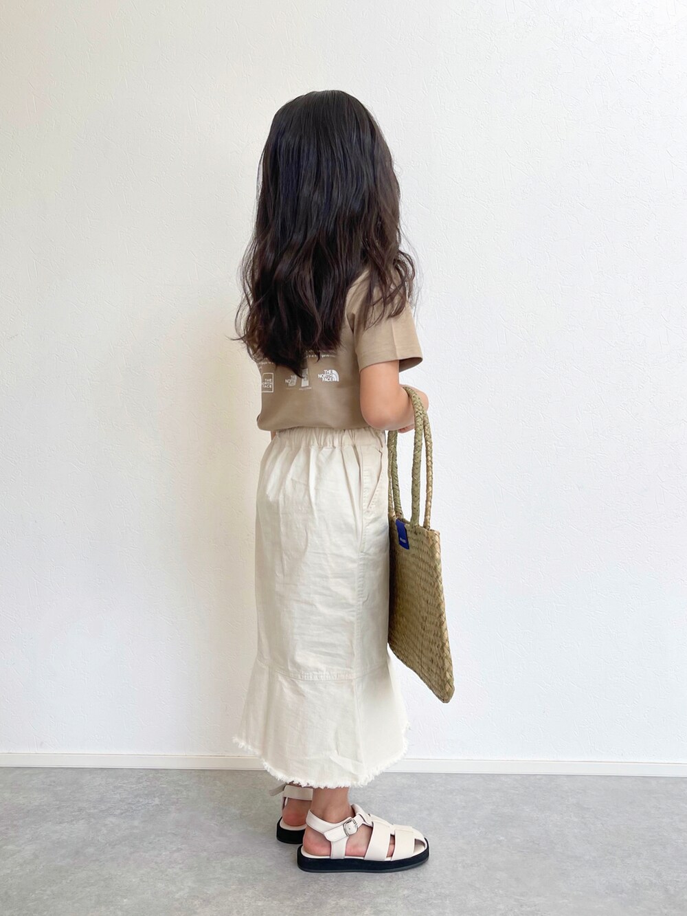 ホワイト系のスカート、ベージュ系のTシャツ/カットソー、ベージュ系のトートバッグを着用したキッズの春コーディネートの4枚目の写真