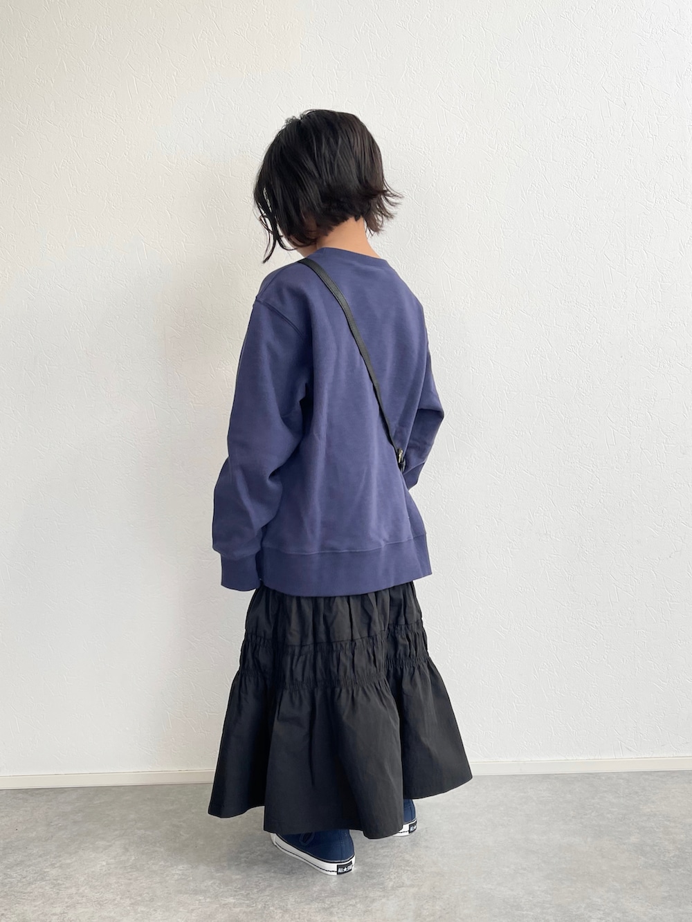 ブラック系のスカート、ブルー系のスウェット、ブルー系のスニーカーを着用したキッズの冬コーディネートの3枚目の写真