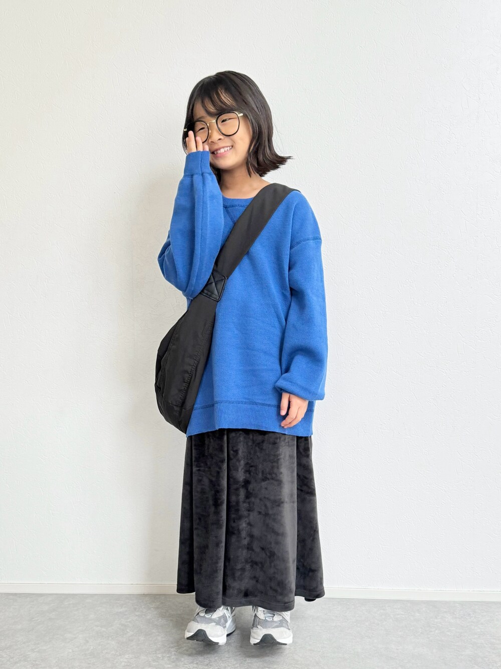 ブルー系のニット/セーター、ブラック系のスカート、グレー系のスニーカーを着用したキッズの冬コーディネートの2枚目の写真