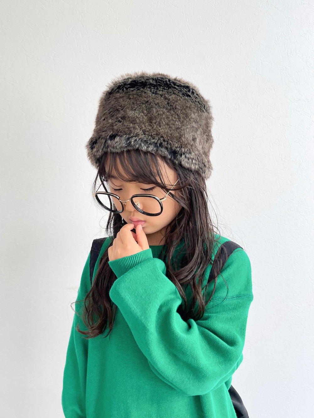 グリーン系のニット/セーター、ブラック系のショルダーバッグ、その他のスカートを着用したキッズの秋コーディネートの3枚目の写真