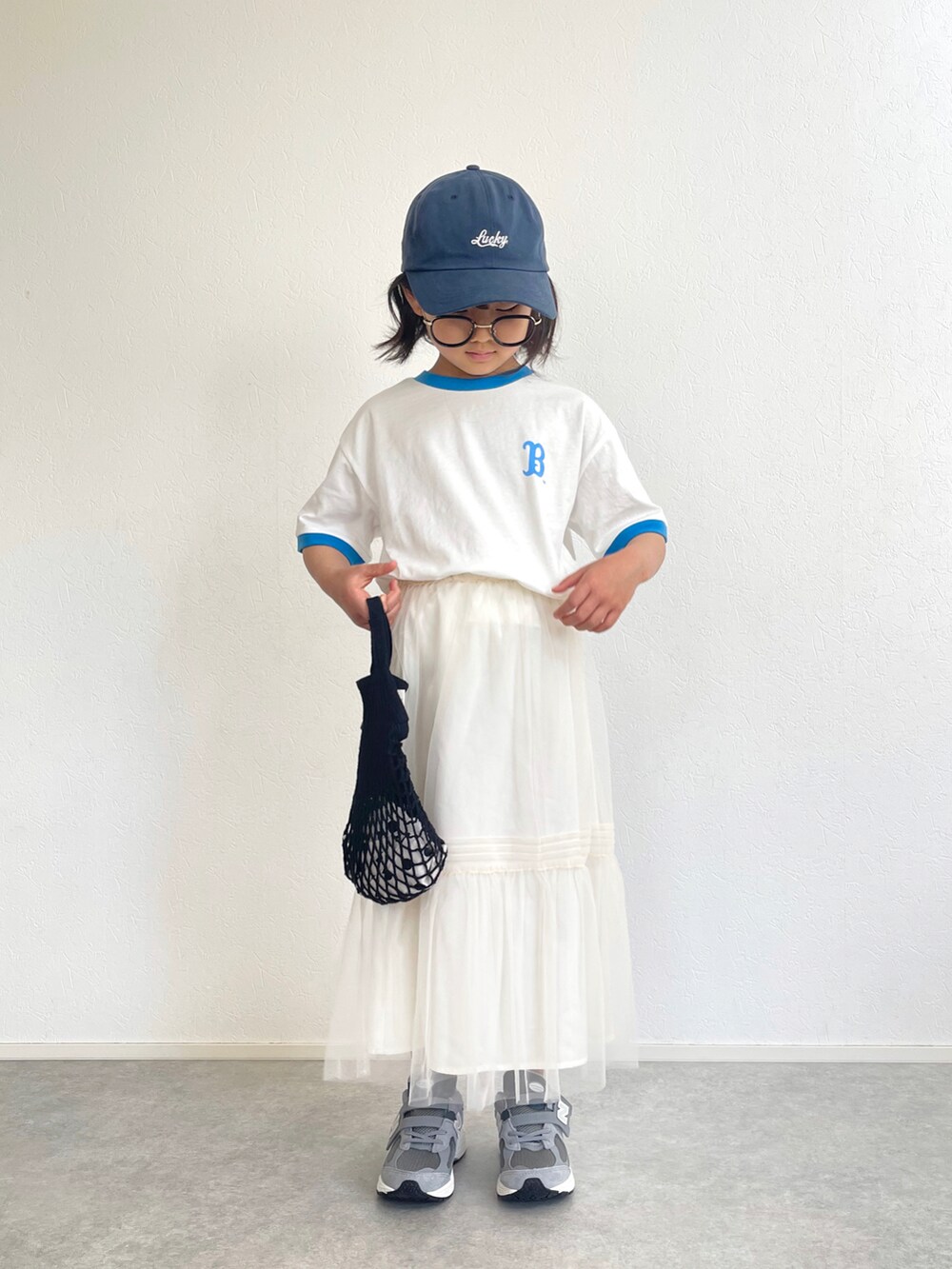 ホワイト系のスカート、グレー系のスニーカー、ホワイト系のTシャツ/カットソーを着用したキッズの春コーディネートの2枚目の写真