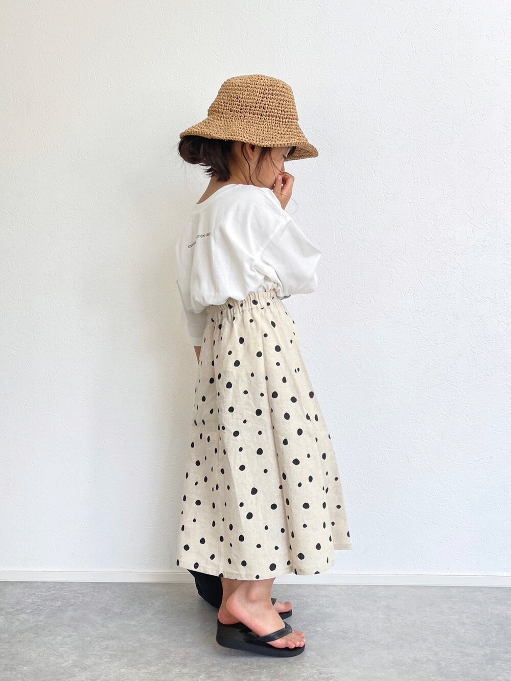 ホワイト系のスカート、ホワイト系のTシャツ/カットソー、ブラック系のエコバッグ/サブバッグを着用したキッズの春コーディネートの3枚目の写真