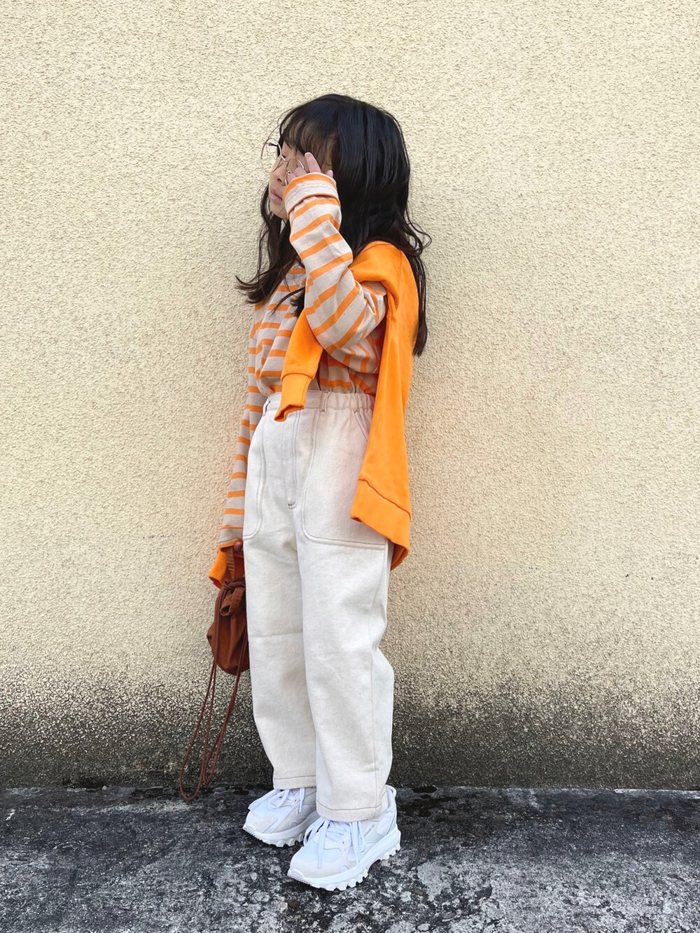 オレンジ系のTシャツ/カットソー、オレンジ系のスウェット、ホワイト系のその他パンツを着用したキッズの冬コーディネートの3枚目の写真