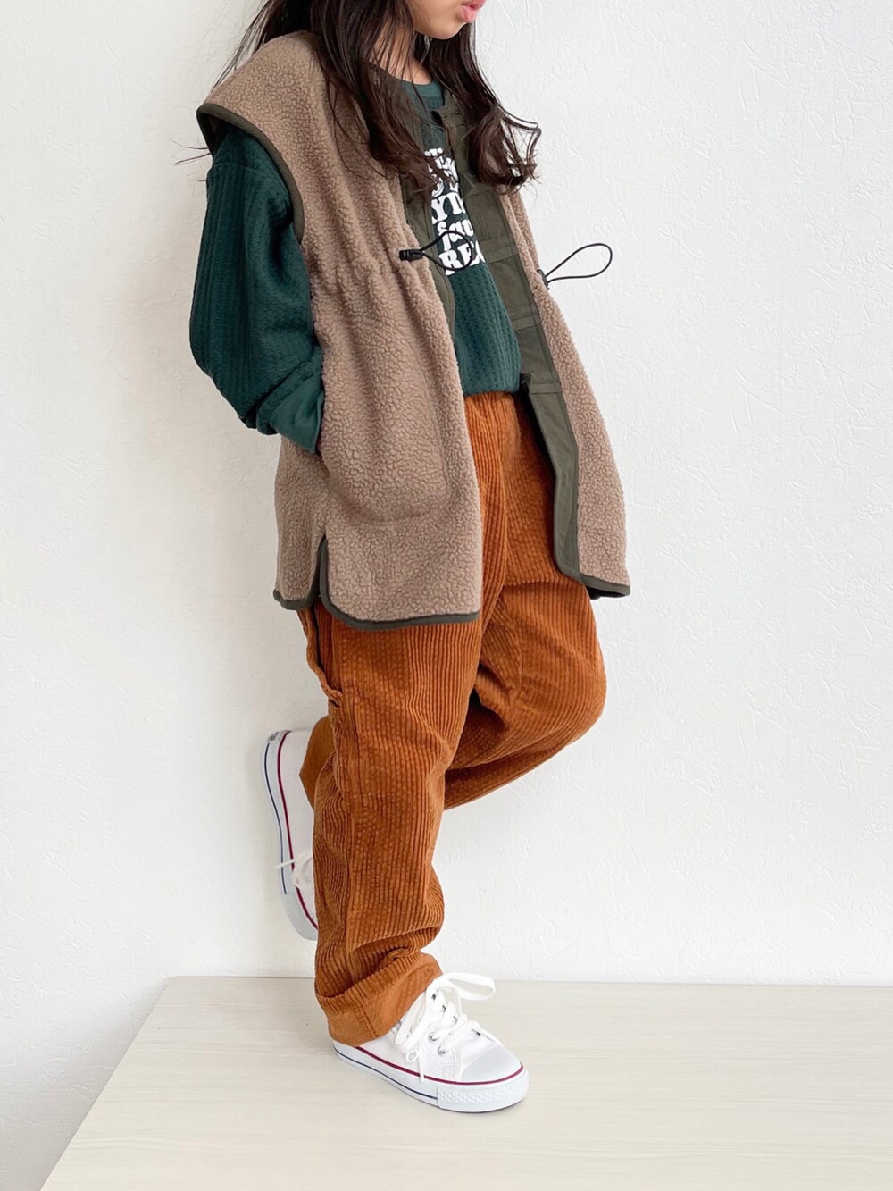 グリーン系のTシャツ/カットソー、ブラウン系のベスト、イエロー系のその他パンツを着用したキッズの秋コーディネートの3枚目の写真