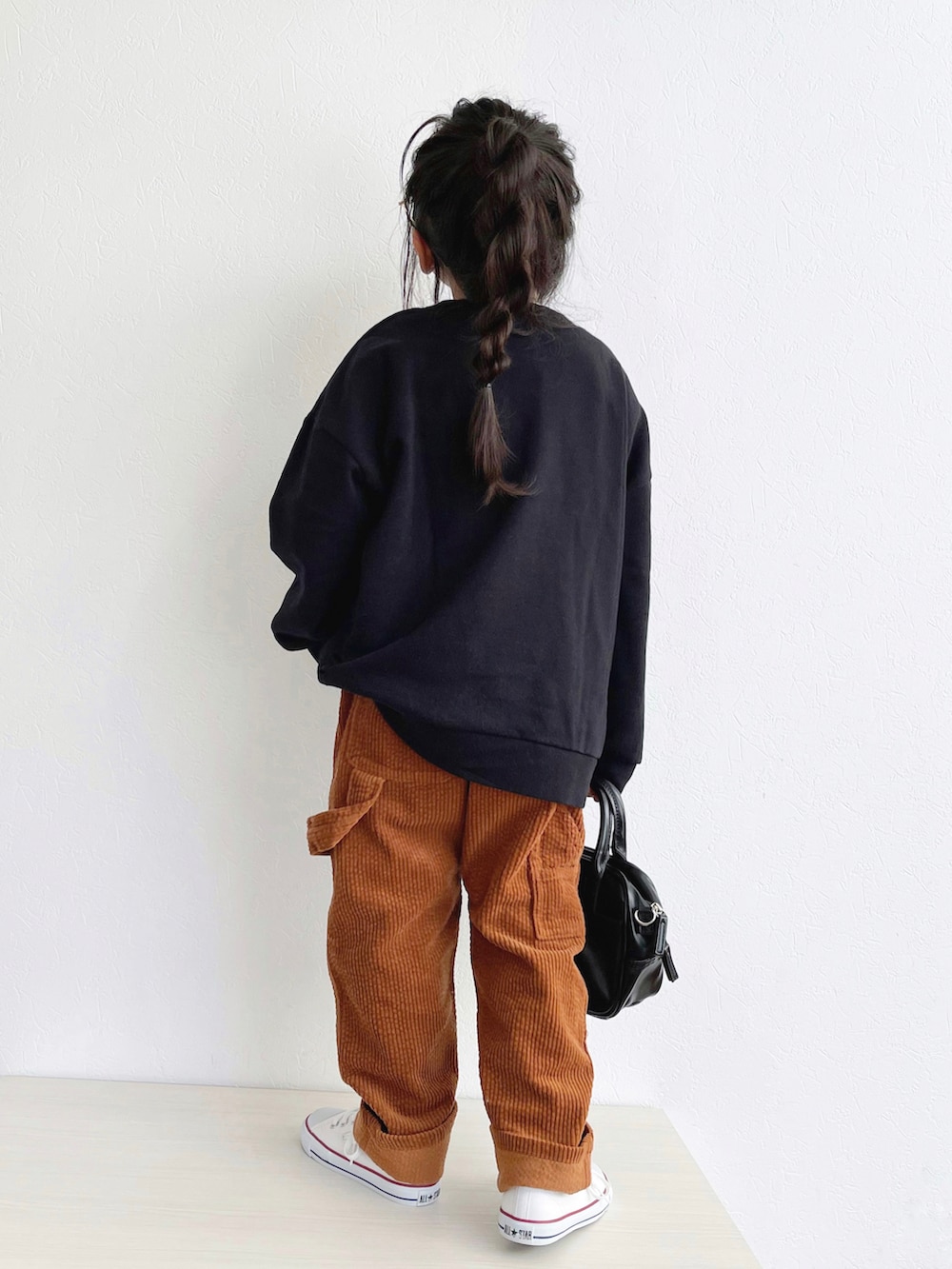 ブラック系のスウェット、イエロー系のその他パンツ、ホワイト系のスニーカーを着用したキッズの秋コーディネートの3枚目の写真