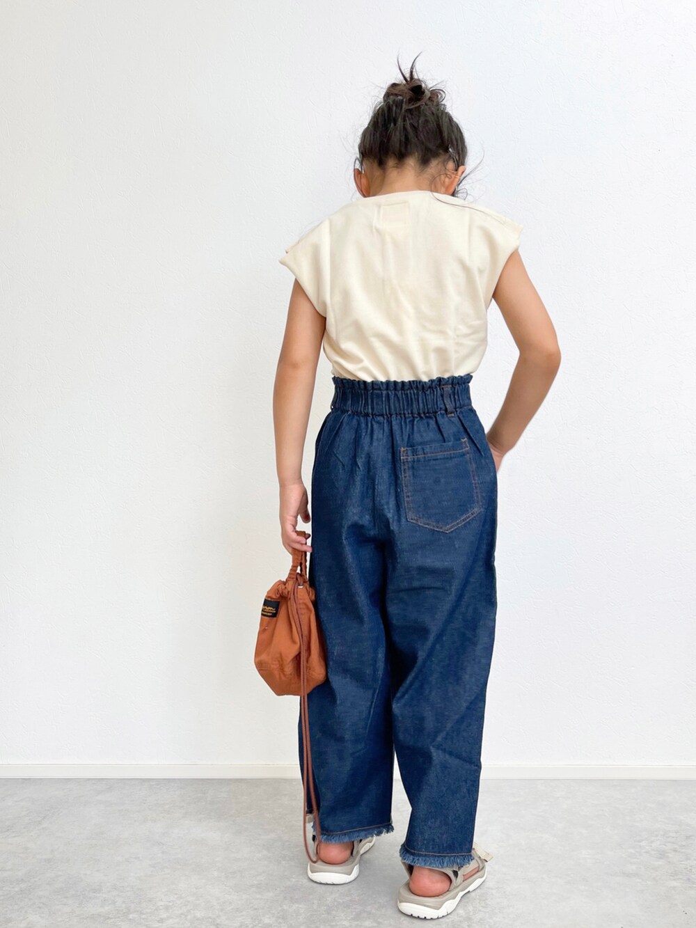 ブルー系のデニムパンツ、ベージュ系のセットアップ、ベージュ系のサンダルを着用したキッズの夏コーディネートの3枚目の写真