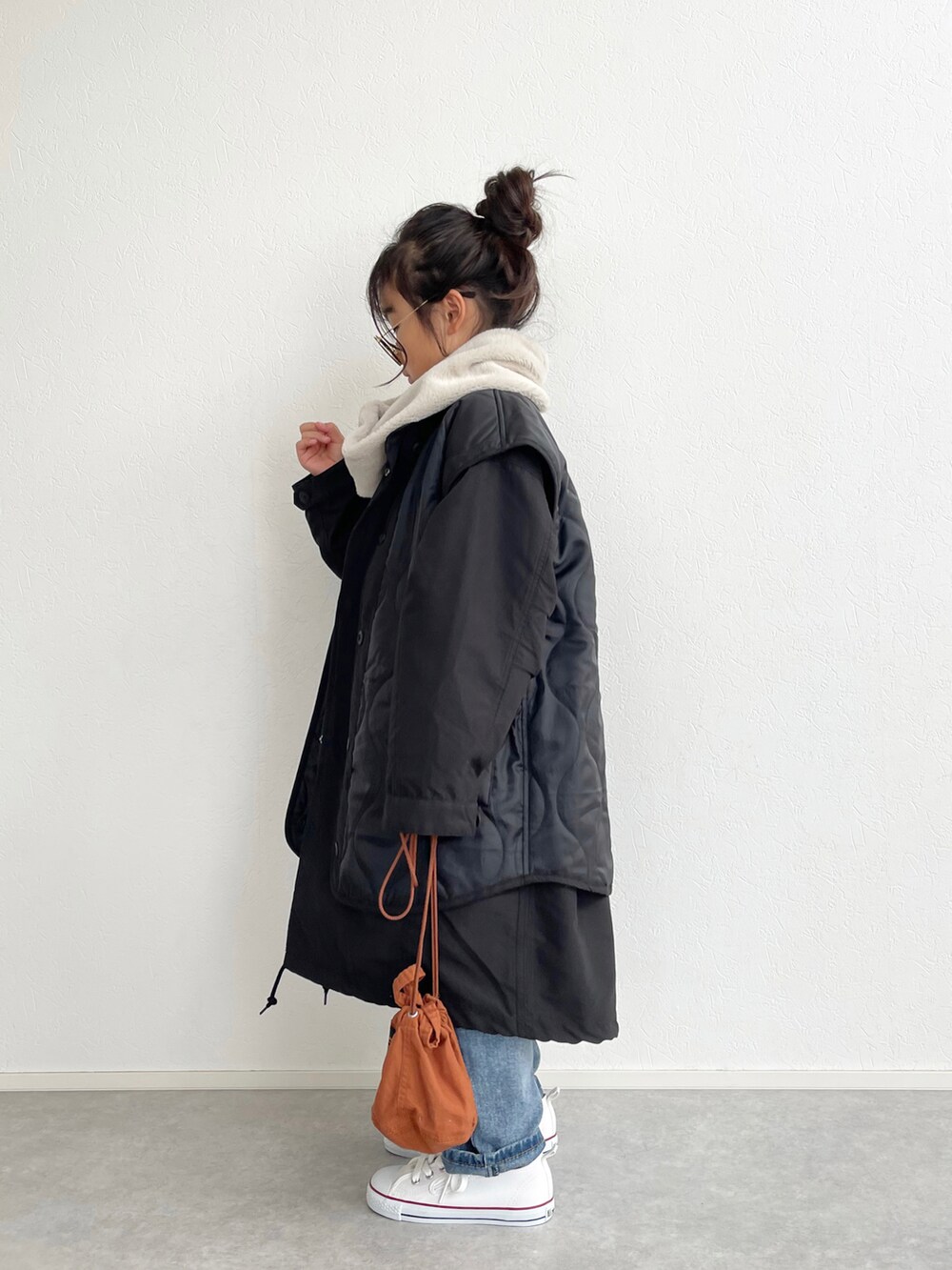 ブラック系のモッズコート、ブルー系のニット/セーター、ブルー系のデニムパンツを着用したキッズの冬コーディネートの3枚目の写真
