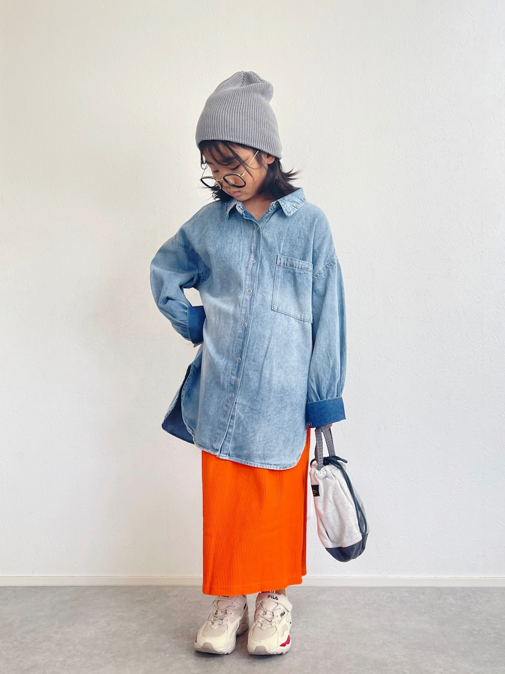 ブルー系のシャツ/ブラウス、オレンジ系のスカート、ベージュ系のスニーカーを着用したキッズの秋コーディネートの2枚目の写真