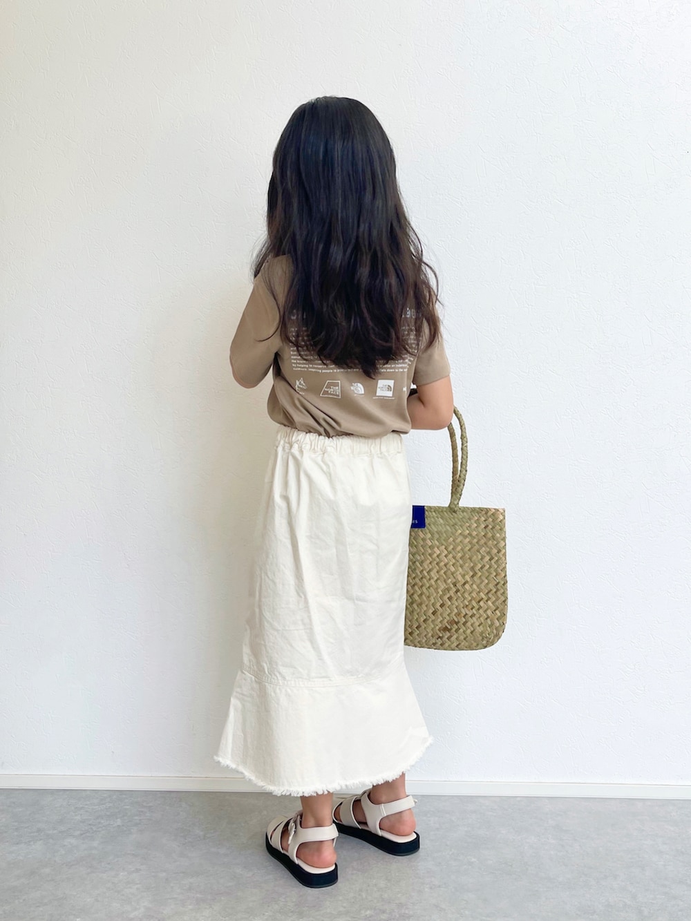 ホワイト系のスカート、ベージュ系のTシャツ/カットソー、ベージュ系のトートバッグを着用したキッズの春コーディネートの5枚目の写真