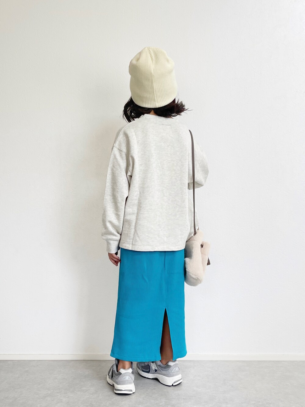 ホワイト系のスウェット、ブルー系のスカート、グレー系のスニーカーを着用したキッズの秋コーディネートの3枚目の写真