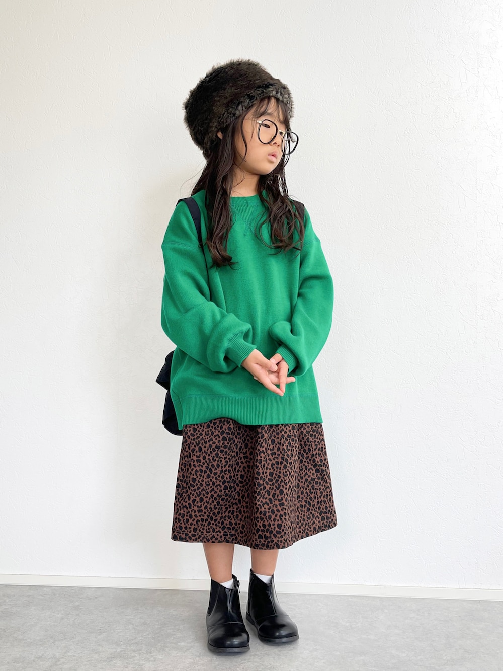 グリーン系のニット/セーター、ブラック系のショルダーバッグ、その他のスカートを着用したキッズの秋コーディネートの2枚目の写真