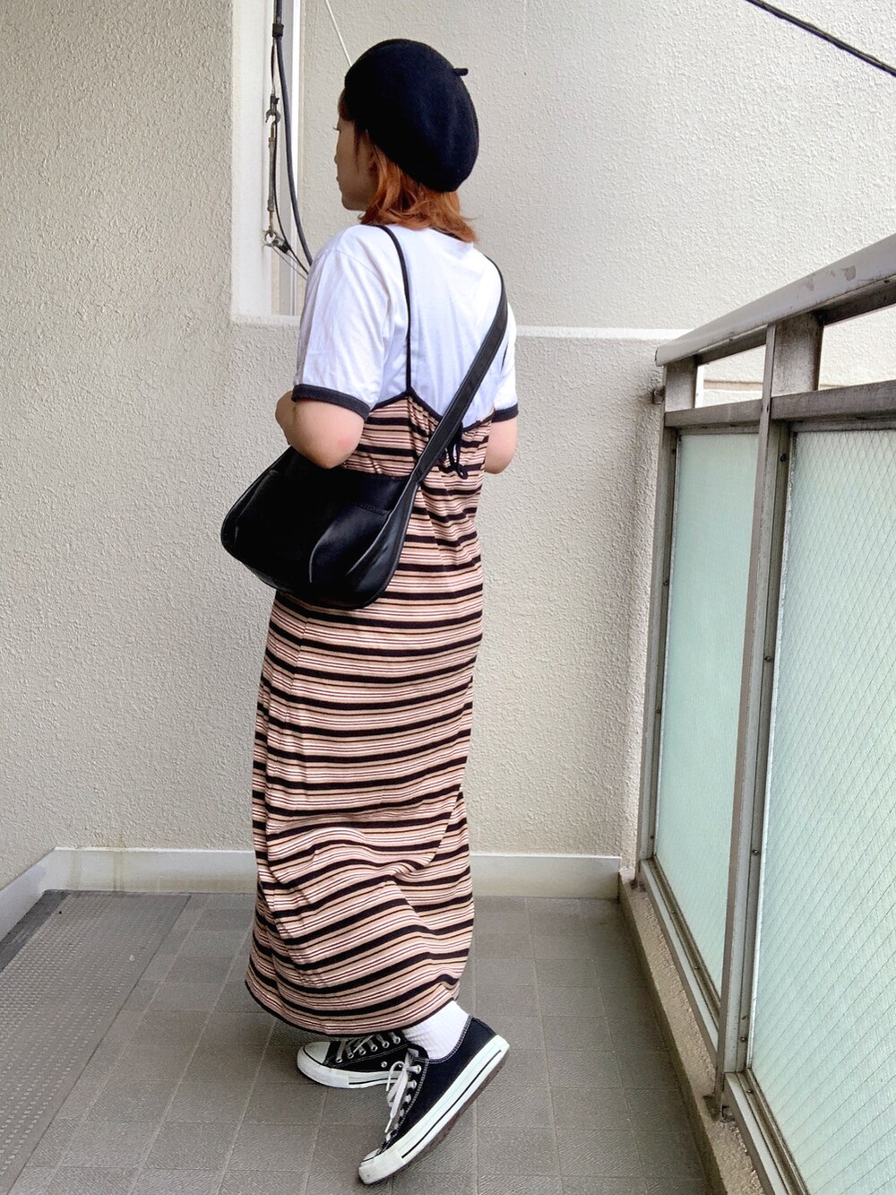 ブラック系のショルダーバッグ、ブラック系のワンピース、ホワイト系のTシャツ/カットソーを着用したレディースの夏コーディネートの3枚目の写真