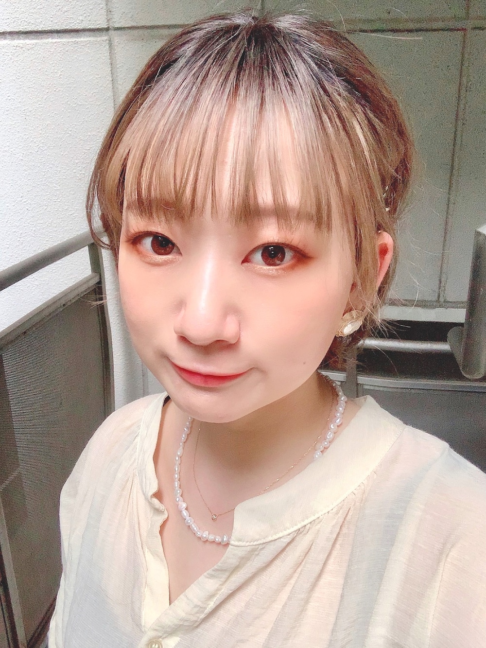 ホワイト系のワンピース、ブラック系のショルダーバッグ、グレー系のデニムパンツを着用したレディースの春コーディネートの3枚目の写真