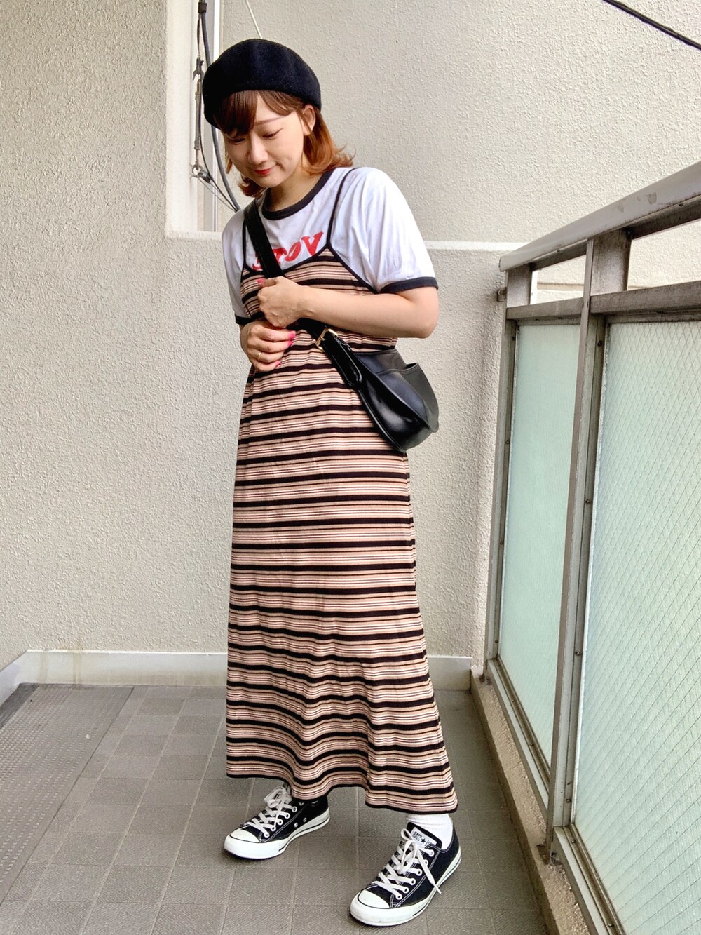 ブラック系のショルダーバッグ、ブラック系のワンピース、ホワイト系のTシャツ/カットソーを着用したレディースの夏コーディネートの2枚目の写真